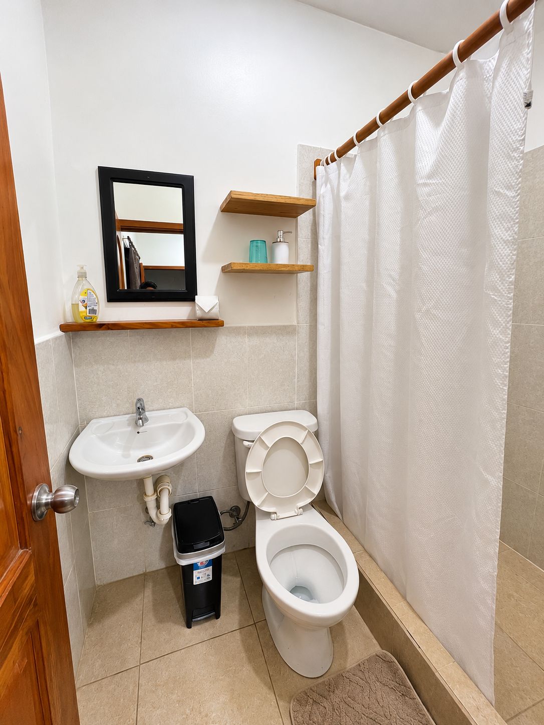 A bathroom with a sink, toilet, and shower curtain.