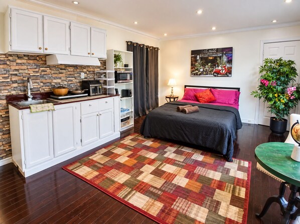 A compact bedroom with a bed, bedside table, and a nightstand.