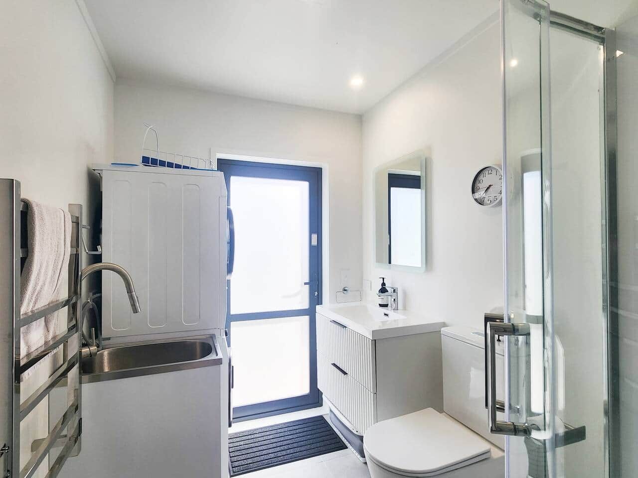 A modern bathroom with a glass shower enclosure, a sink, and a toilet.