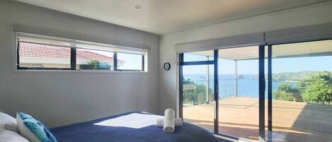 A bedroom with a bed, a window, and a view of the outdoors.