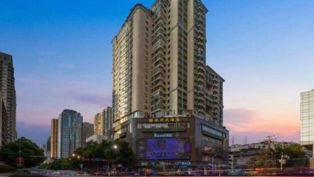 Un edificio alto con varios balcones, rodeado de otras estructuras elevadas.