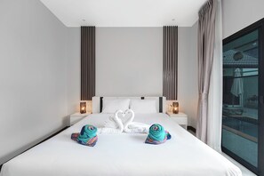 Ein Hotelzimmer mit einem großen Bett, zwei Nachttischen, einem Fenster mit Blick auf einen Pool und Handtüchern, die zu einem Schwan geformt sind.