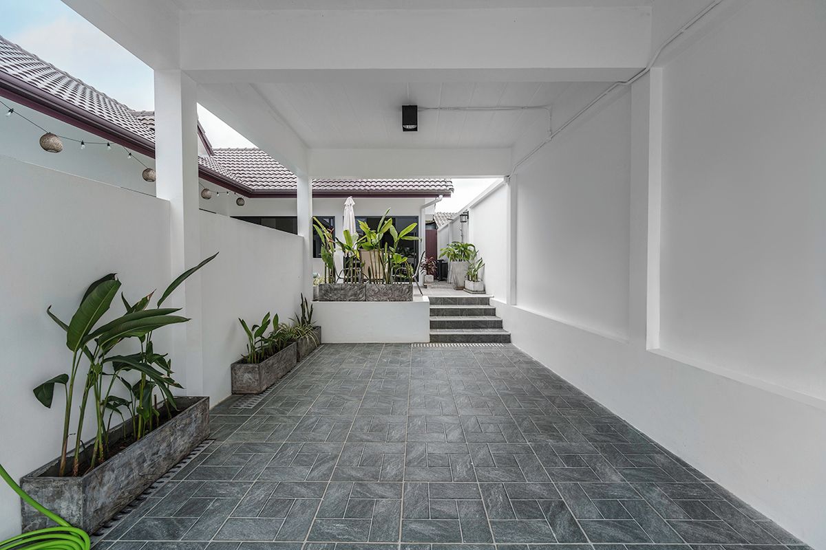 A clean, modern interior with a tiled floor, white walls, and a staircase leading to an upper level.