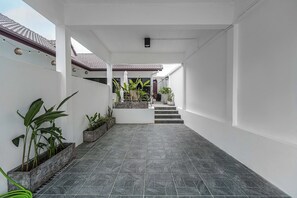 Ein sauberes, modernes Interieur mit Fliesenboden, weißen Wänden und einer Treppe, die in eine obere Ebene führt.