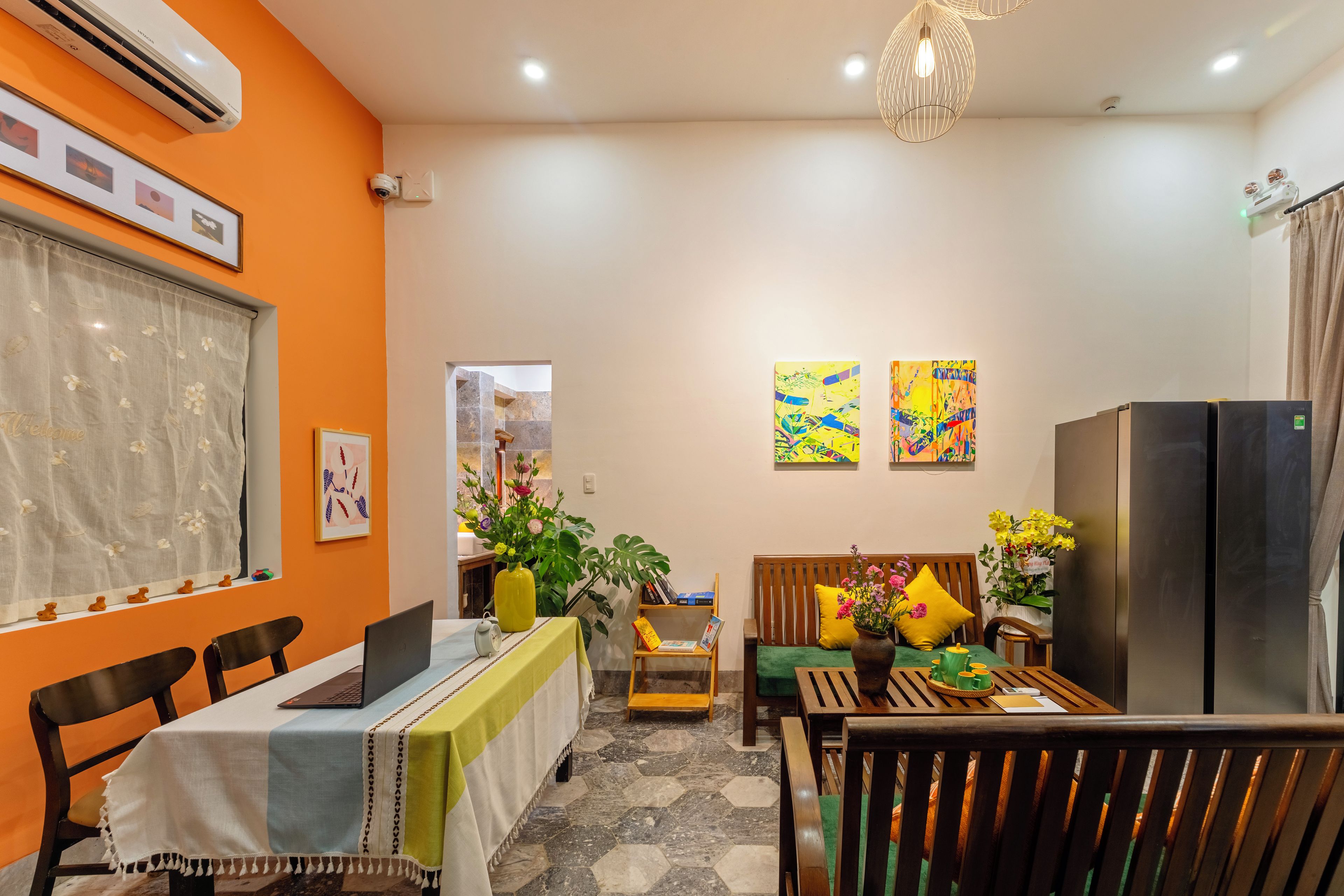 Cocina moderna con comedor, que incluye un refrigerador, una mesa con sillas y una lámpara colgante.
