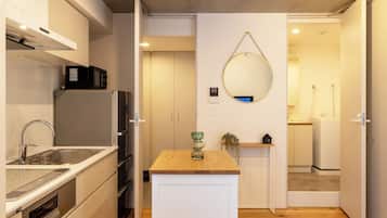 A compact kitchen with a built-in oven, microwave, and a sink with a modern faucet.