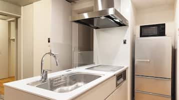 Una cocina moderna con un lavamanos de acero inoxidable, un microondas y un horno empotrado.
