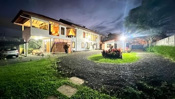 Une maison à deux étages avec une allée et une pelouse bien entretenue.