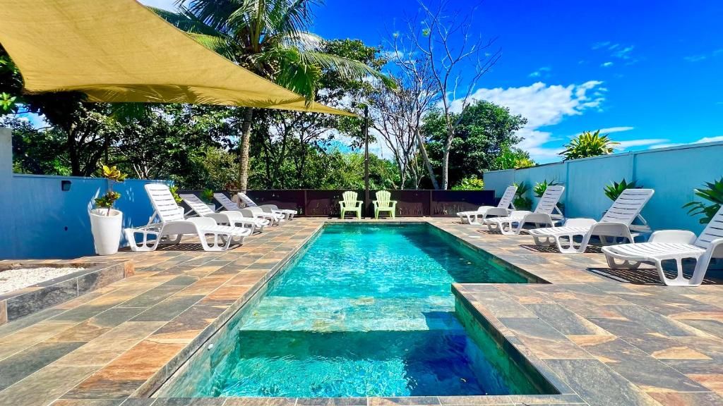 A swimming pool with lounge chairs and a shaded area.