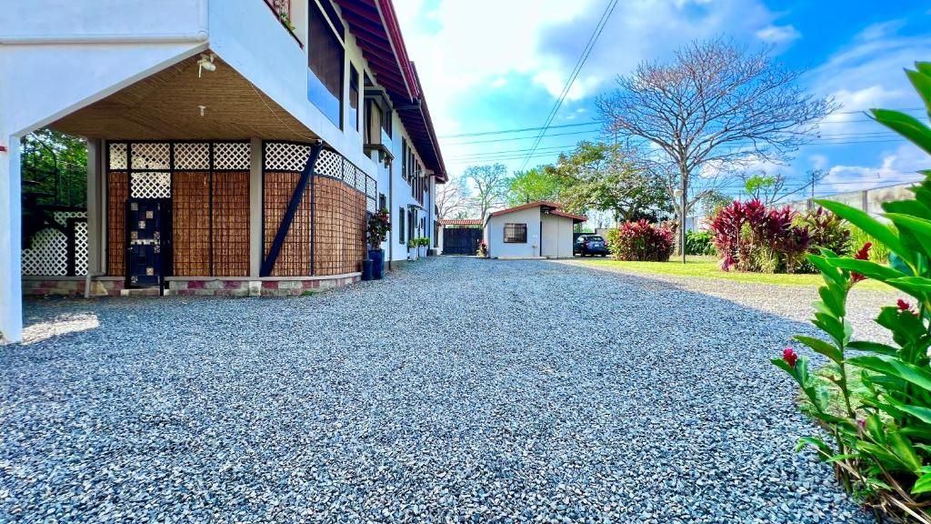 A residential property with a covered porch, a gravel driveway, and a small garden area.