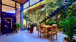 A wooden table and chairs in a covered outdoor area with a sign reading 'Ruta Verde House.' - Ruta Verde BB (Tambor)