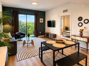 Ein modernes Wohnzimmer mit einer Couch, einem Couchtisch und einem Essbereich mit Tisch und Bänken.