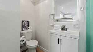Ein Badezimmer mit Toilette, Waschbecken, Spiegel und Handtuchhalter.