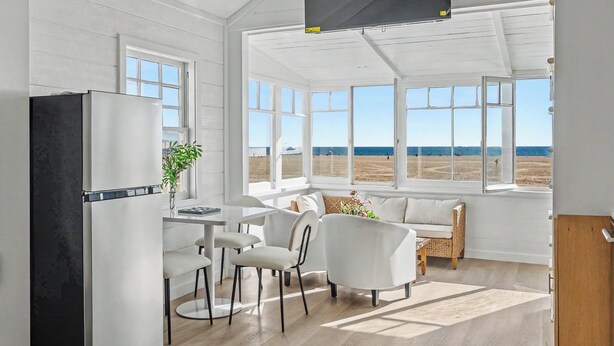 Eine moderne Küche mit einem großen Fenster mit Blick auf einen Strand.