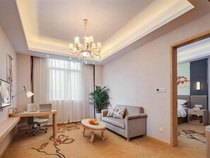 A modern hotel room with a desk, sofa, and a dining area. - Vienna International Hotel (Nanjing)