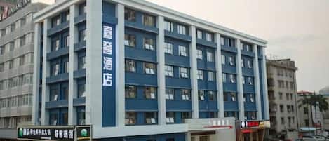 Un edificio de hotel de varios pisos con fachada azul y ventanas blancas.
