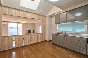 Eine moderne Küche mit Oberlicht, Holzboden und Einbaugeräten.