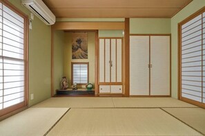 Ein traditioneller japanischer Raum mit Tatami-Böden, Schiebetüren und einem Shoji-Bildschirm.