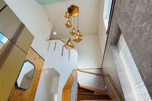 Eine Treppe mit Holzwangen und einer modernen Leuchte.