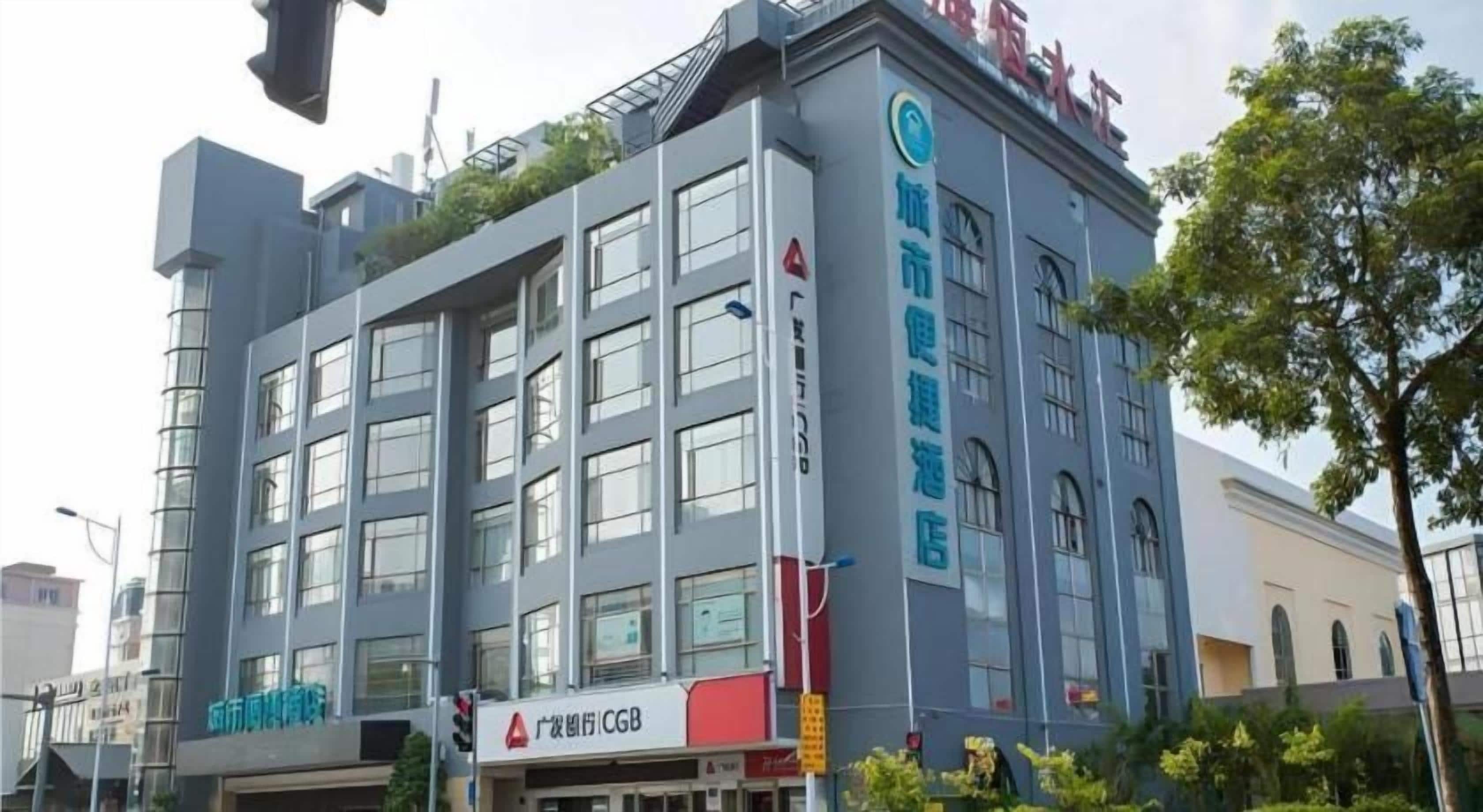 A multi-story building with signage for a convenience store and a health club.