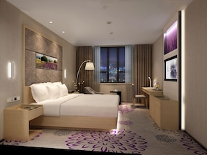 A modern hotel room with a large bed, a desk, a chair, a nightstand, a window with a city view, and a decorative wall panel. - Lavande Hotel (Dongguan)
