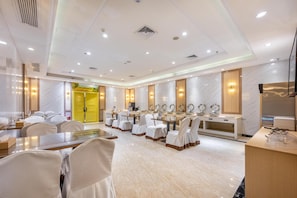 A hotel conference room with a long table, multiple chairs, and a buffet area. - Vienna Hotel (Dongguan)