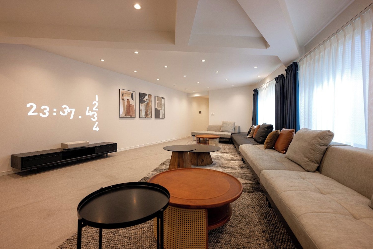 Ein modernes Wohnzimmer mit einer Couch, einem Couchtisch und Kunstwerken an der Wand.