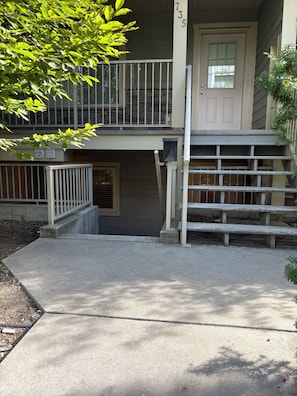 Un bâtiment à deux étages, doté d’une entrée principale, d’un petit porche et d’un escalier en béton menant à la porte.