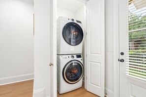 A laundry room with two stacked washing machines, one labeled 'Dry' and the other 'Wash'.