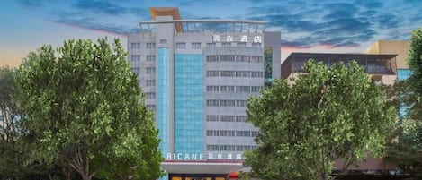 Un hotel con fachada moderna, varios pisos y una entrada destacada.