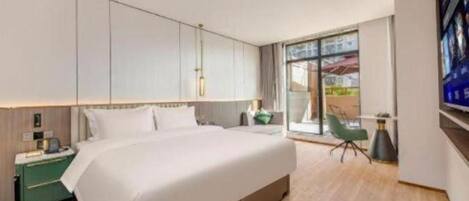 Una habitación de hotel moderna con una cama grande, un escritorio y un televisor.