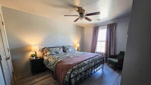 A bedroom with a bed, bedside lamps, a ceiling fan, and a window with curtains. - FamilyFriendly 2BR,King bed @ Fort Sill & Lawton #1 (Elgin)