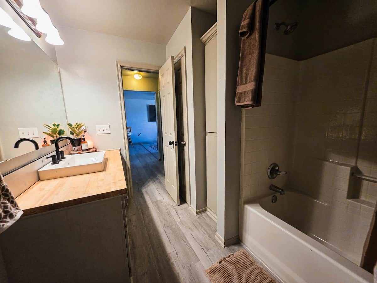 Un baño con bañera, lavabo y espejo.