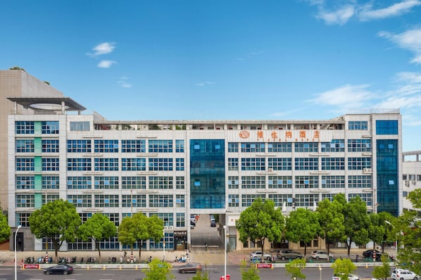 Un edificio moderno con varios pisos, ventanas amplias y cielo despejado.