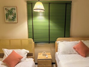 A hotel room with two beds, a bedside table with a lamp, a framed picture on the wall, and a window with green blinds. - Moon house 5BR Near Walking Street  (Nongprue)