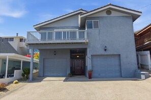 A two-story house with a balcony, a garage, and a front door. - 3 bedroom beach view home in Morro Bay! Room for the family- medium term rental (Morro Bay)