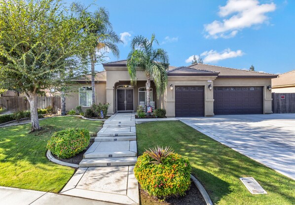 A residential house with a front yard, a driveway, and a garage.