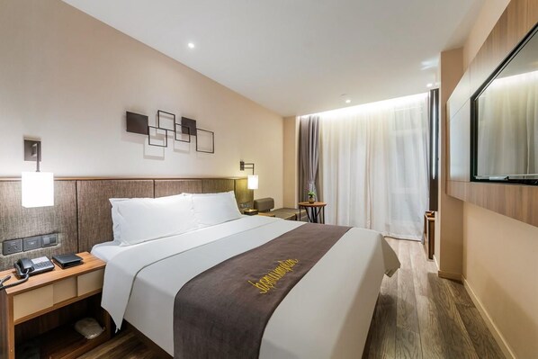 A hotel room with a bed, bedside table, lamp, and a mirror. - Home Inn Plus Shanghai Pudong Jinqiao (Shanghai)
