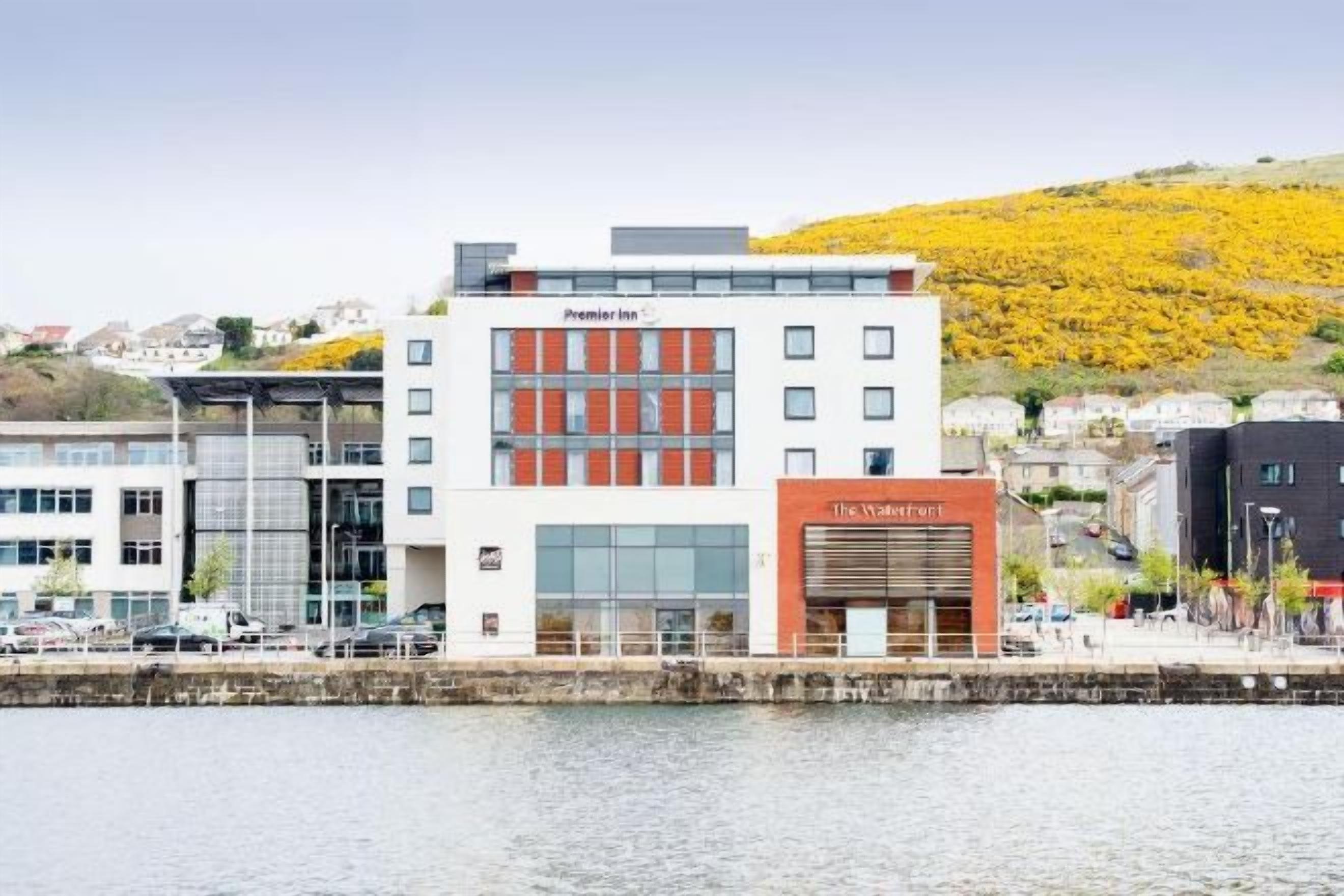 A hotel with a modern facade, a prominent entrance, and a waterfront view.