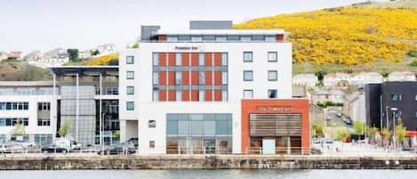 A hotel with a modern facade, a prominent entrance, and a waterfront view.