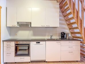 A kitchen with white cabinets, an oven, a dishwasher, and a coffee maker. - Renovated 2 BD+ loft by the lake, free wifi, sauna (Kuusamo)