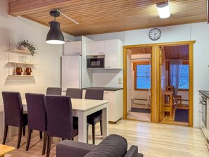 A compact living space with a dining area, kitchenette, and a view through an open doorway. - Renovated 2 BD+ loft by the lake, free wifi, sauna (Kuusamo)