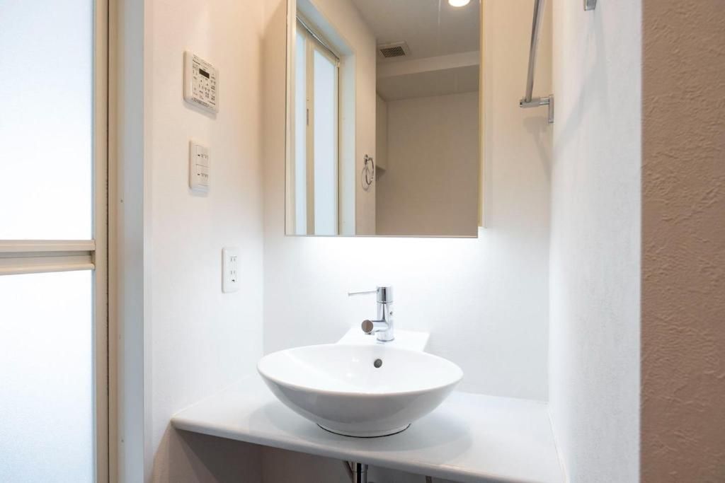 A bathroom with a white sink, a mirror, and a shower curtain.