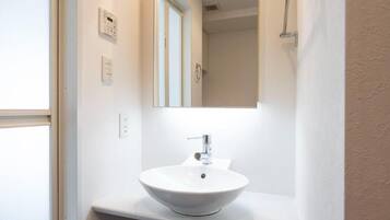 A bathroom with a white sink, a mirror, and a shower curtain.