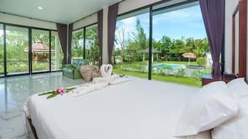 Habitación de hotel con una cama grande, vista a una piscina y pared de vidrio.