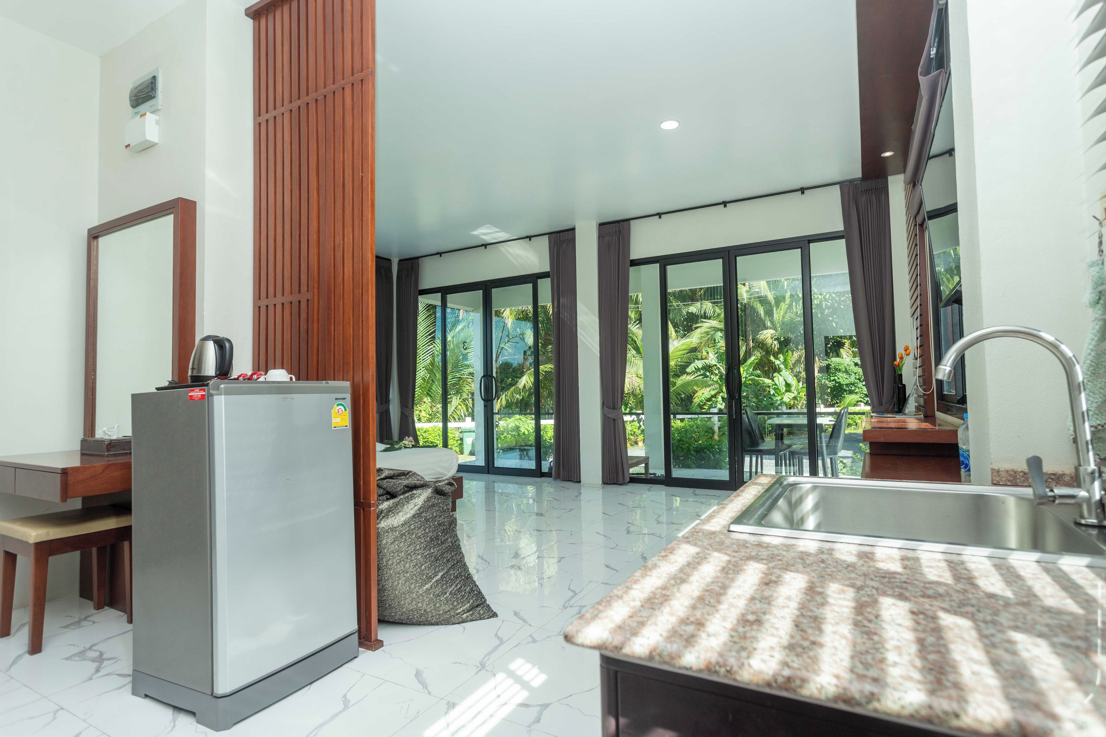 Una cocina moderna con refrigerador, lavamanos y comedor con mesa y sillas.