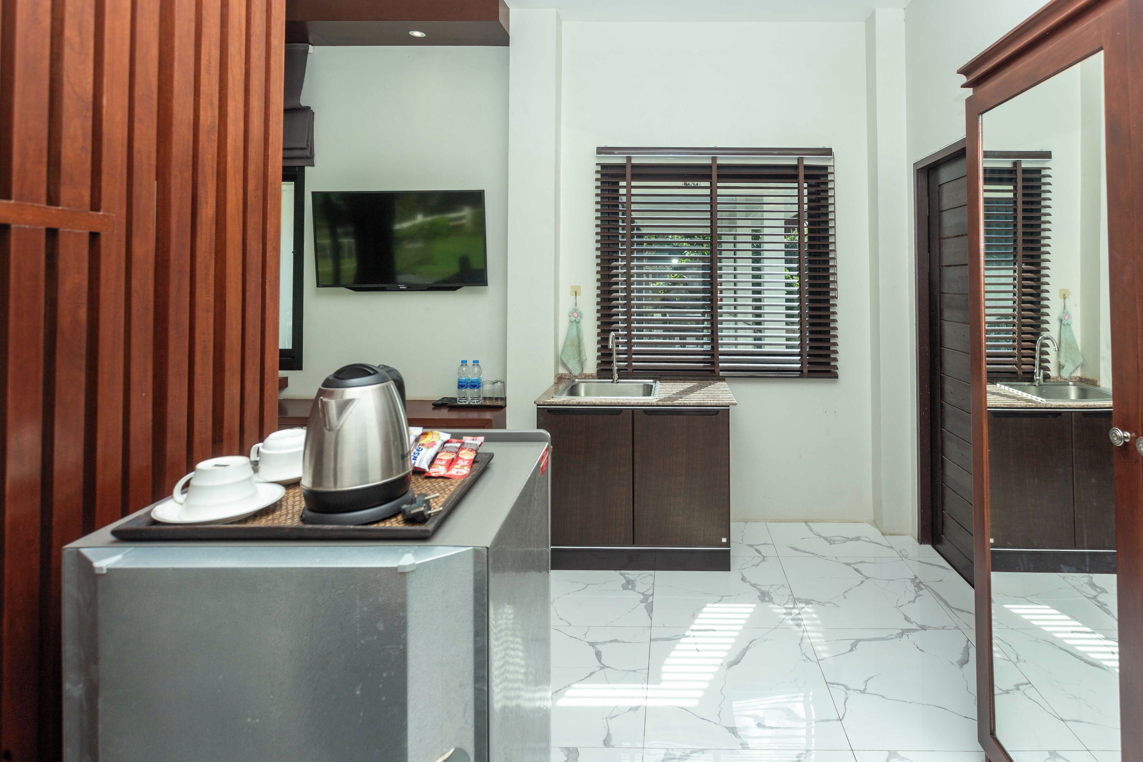 Una cocina compacta con cafetera, dispensador de agua y una pequeña encimera.