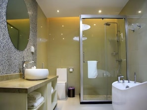 A modern bathroom with a glass-enclosed shower, a freestanding bathtub, and a large mirror with mosaic tile backsplash. - Lavande Hotel (Lanzhou)