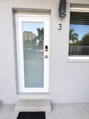 A white door with a frosted glass panel and a 'No Smoking' sign, a number '3' on the wall, and a window with blinds. - Private-Patio Studio near Miami Beach (Miami)
