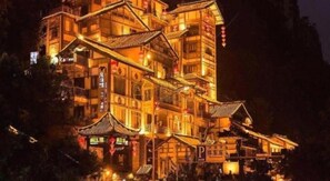 A multi-story building with traditional architecture, featuring balconies and signage. - Xana Hotelle Jiefangbei Pedestrian Street Zhongxin (Chongqing)